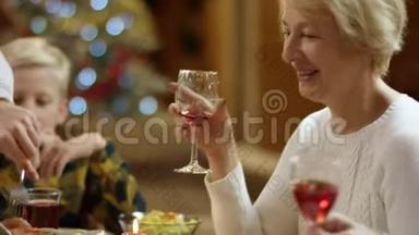 一个男人在圣诞家庭餐桌上切鸡腿，老太太在等他